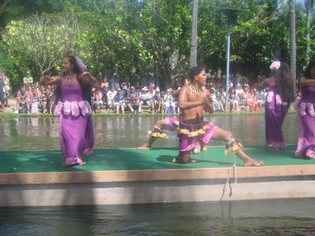 Performers dressed in purple on float at Polynesian Cultural Center.