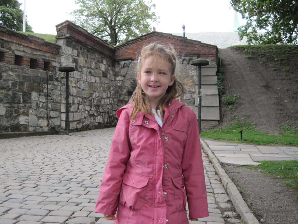 Young girl in pink jacket at Akershus Fortress in Oslo, Norway.