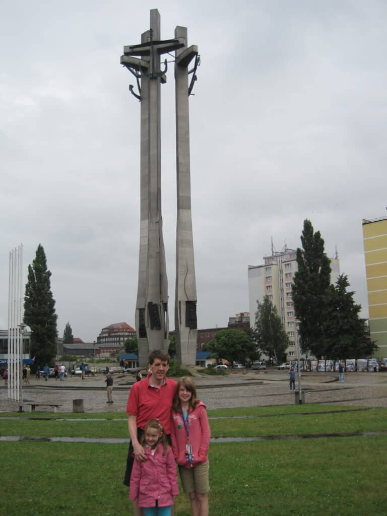 Dad with two girls standing at the Solidarity Monument in Gdansk, Poland.