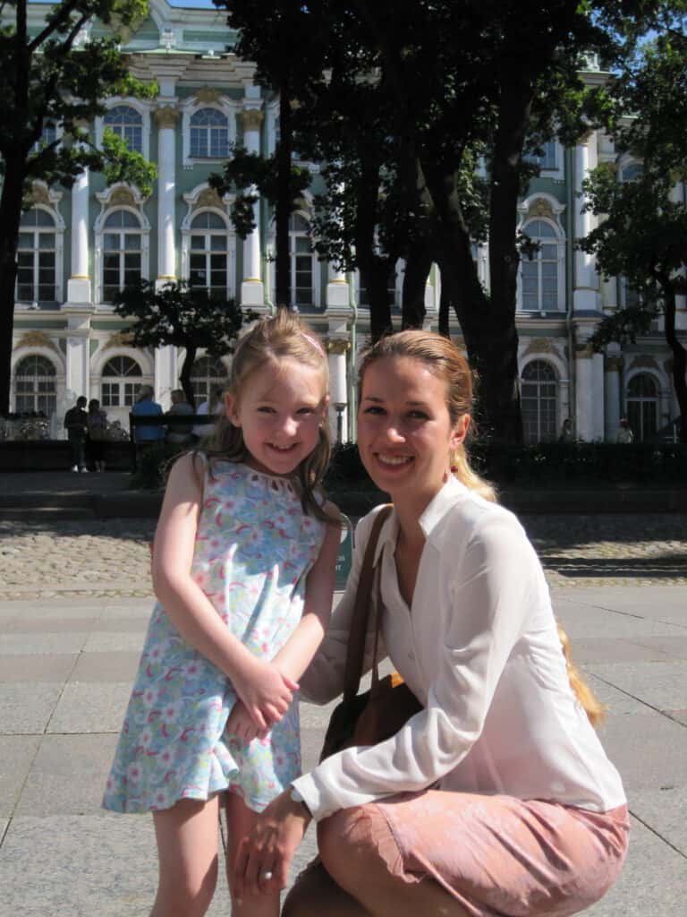 Young girl and woman posing outside the Winter Palace in St. Petersburg, Russia.