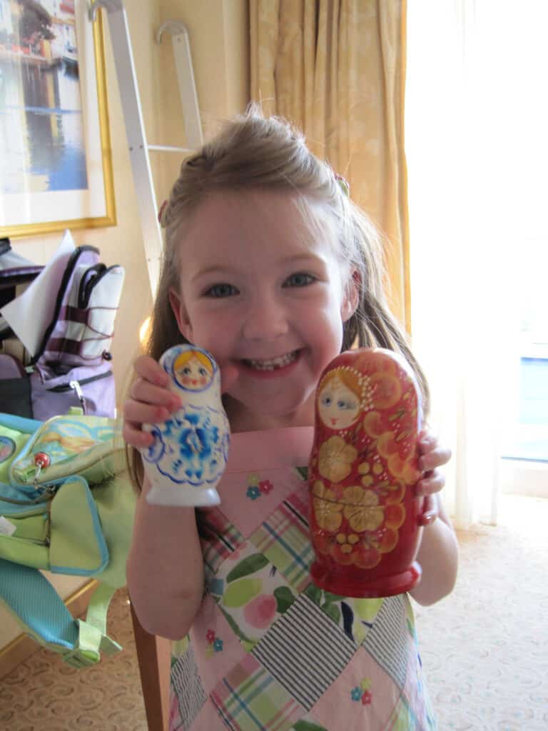 Young girl holding two matryoshka dolls.