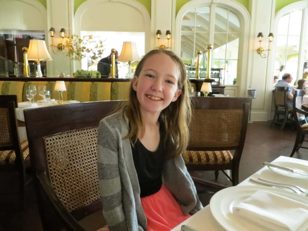 Young girl sitting at table in Cafe Martinique at Atlantis Bahamas.