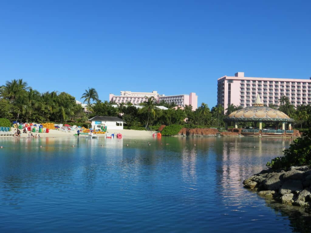 Paradise Lagoon with rental equipment on beach and pink beach and coral towers in background.