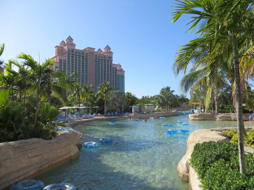 The Current lazy river at Atlantis Bahamas with blue clear inner tubes in water and tower in background.