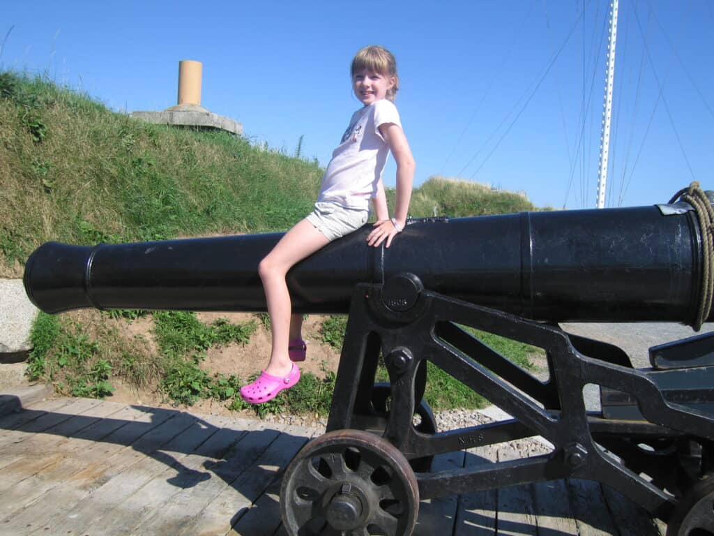 Young girl sitting on top of cannon at the Halifax Citadel.