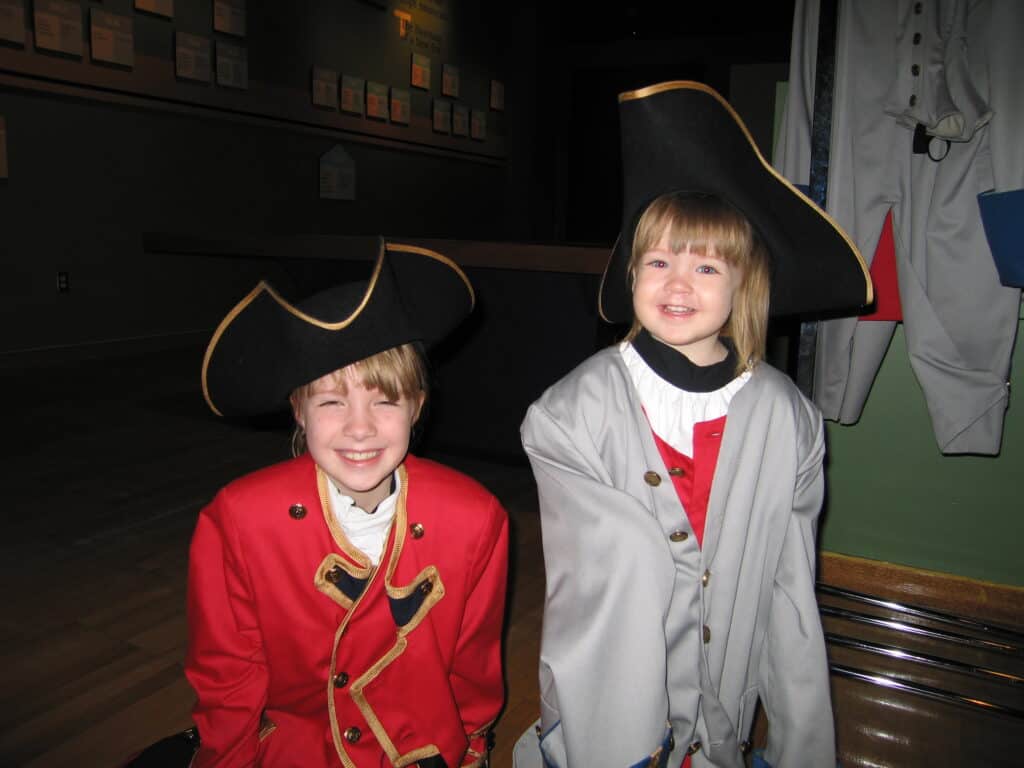 Two young girls dressed in costume uniforms of british and french at musee de la civilisation in quebec city.