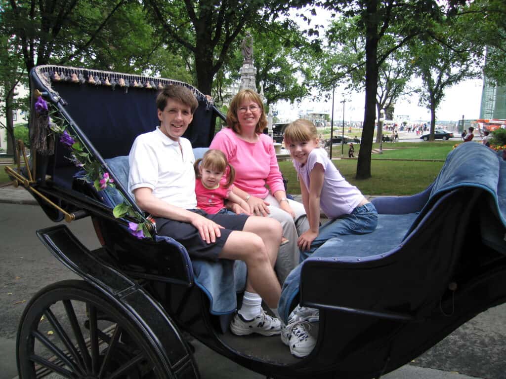 Mom, dad and two young girls in carriage in Quebec City.