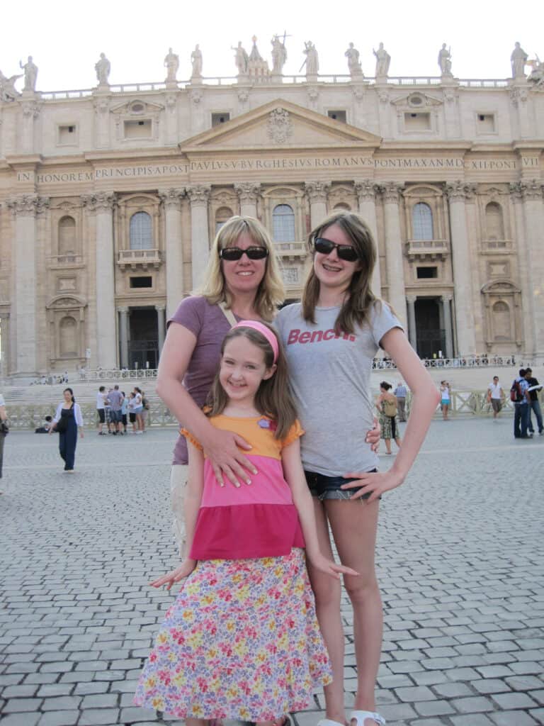 mom with teenage daughter and younger daughter outside st. peter's basilica in rome.