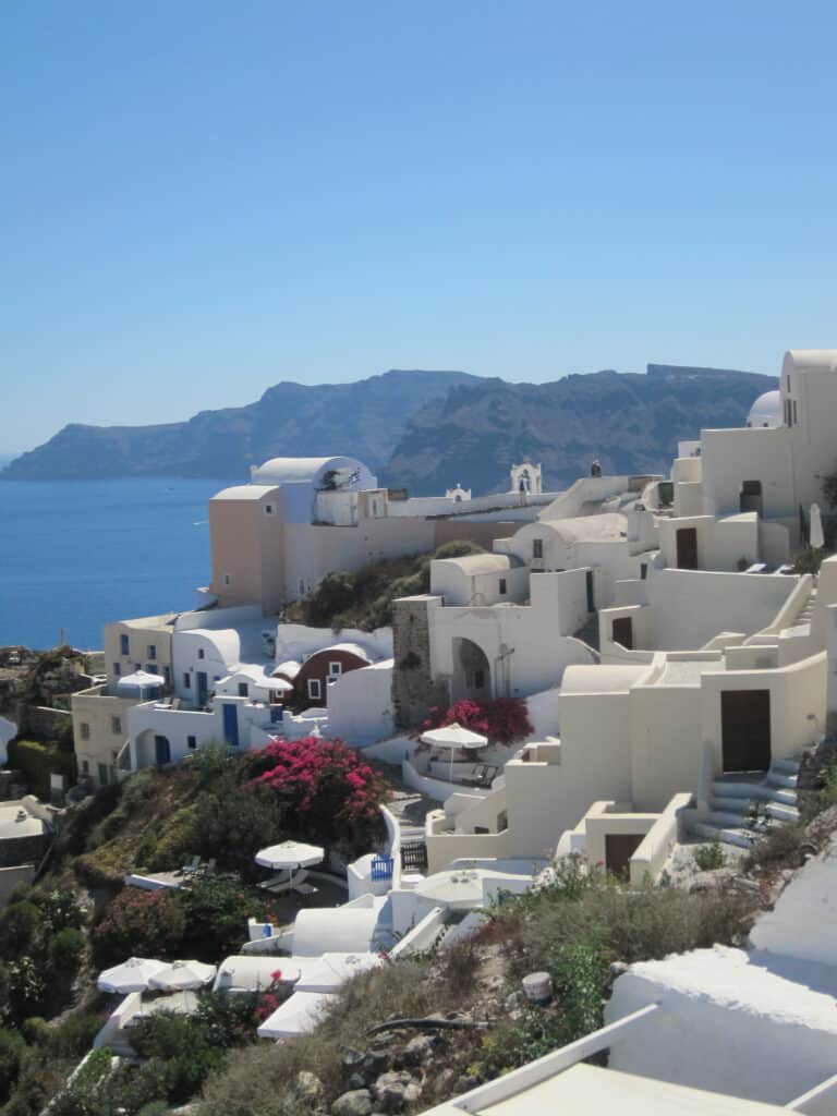 Oia, Greece - white cliffside buildings with caldera in background.