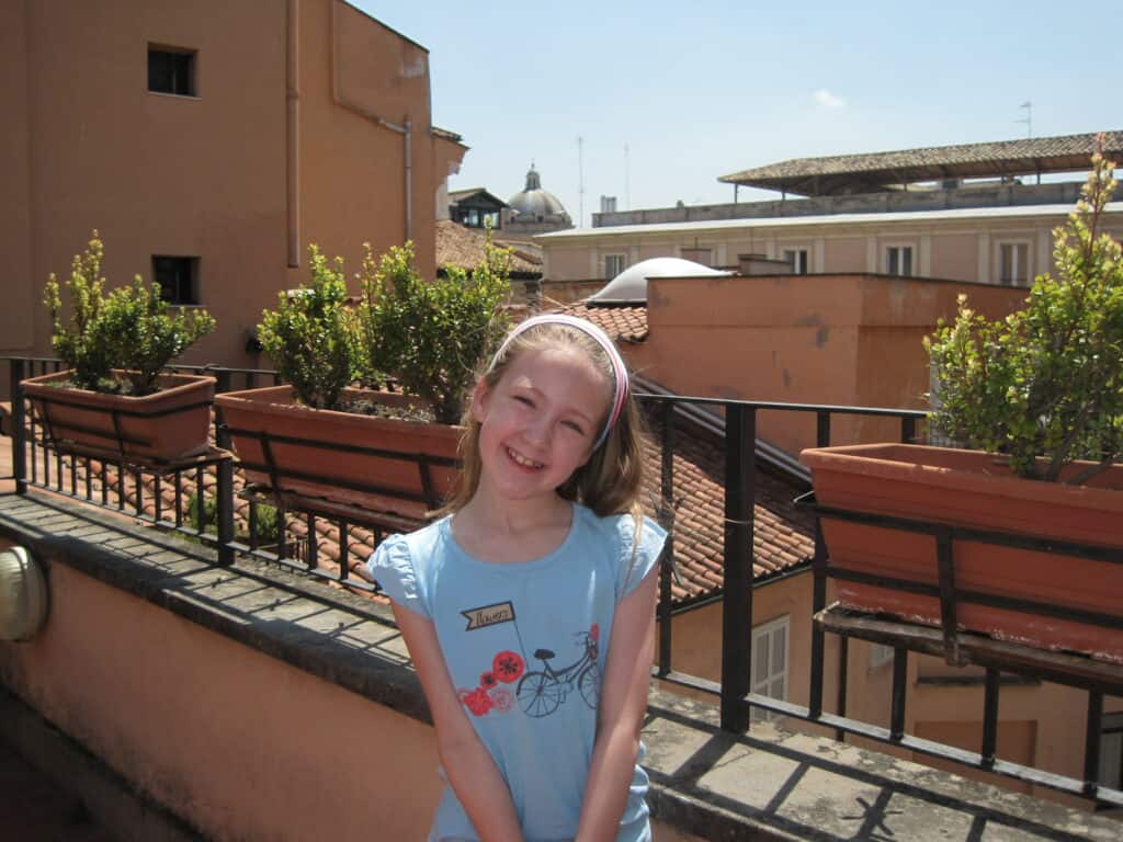 young girl standing on terrace in Rome, Italy.