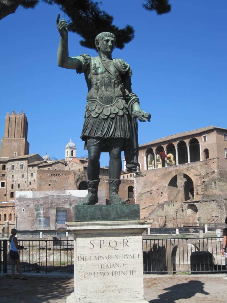 statue along street in rome set against bright blue cloudless sky.