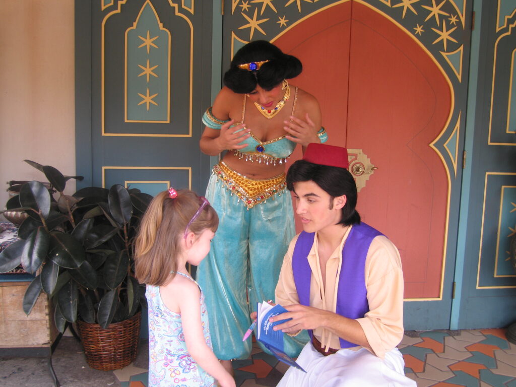 Young girl meeting Aladdin and Jasmine at Disney World.