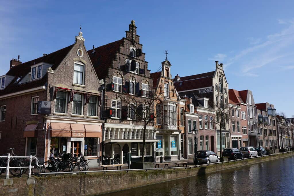 Buildings, cars and bicycles alongside canal in Alkmaar, Netherlands.