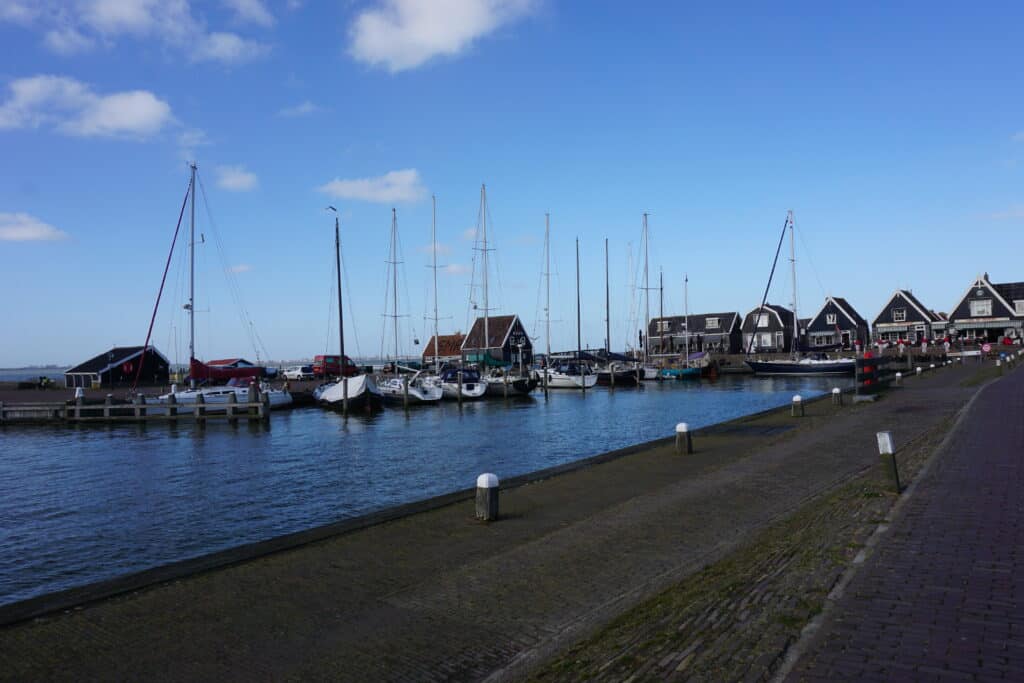 Buildings along waterfront and boats in water in Marken, Netherlands.