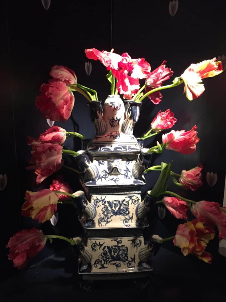 Pink and white tulips on display in blue and white ceramic tulip vase at Amsterdam Tulip Museum.