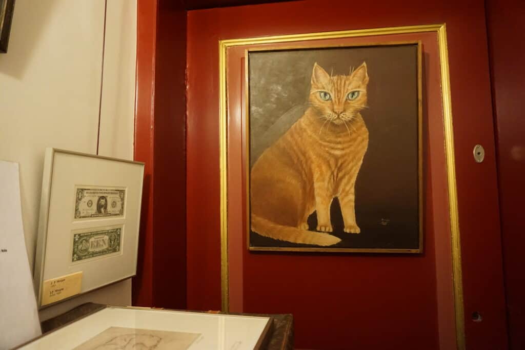 JP Morgan Memorial at Kattinkabinet in Amsterdam - painting of ginger cat hanging on red painted wall