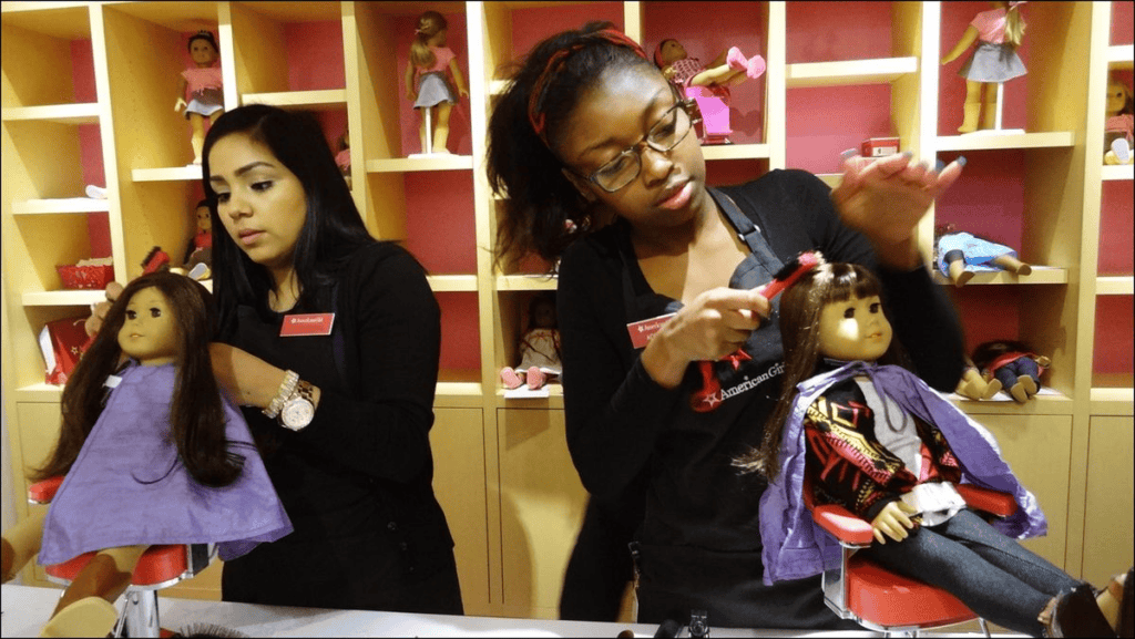 Two women styling dolls hair at American Girl Place.