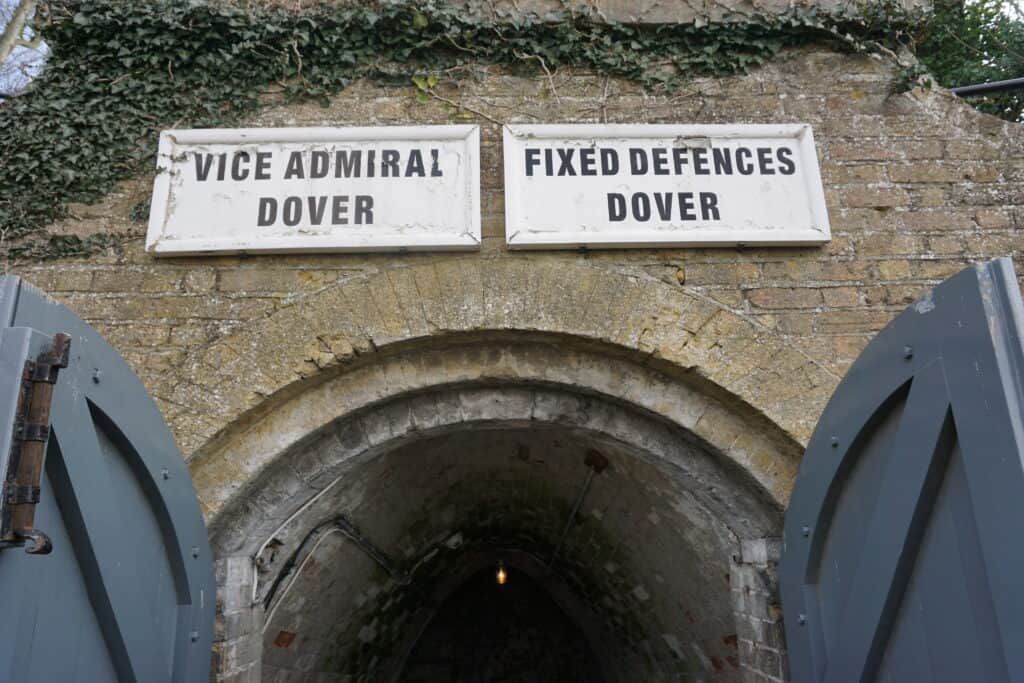 Entrance to wartime tunnels at Dover Castle - doors open to tunnel with two white signs with black lettering above - one reading Vice Admiral Dover and the other Fixed Defences Dover.