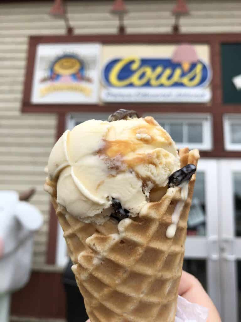 Cows ice cream cone with sign in background.