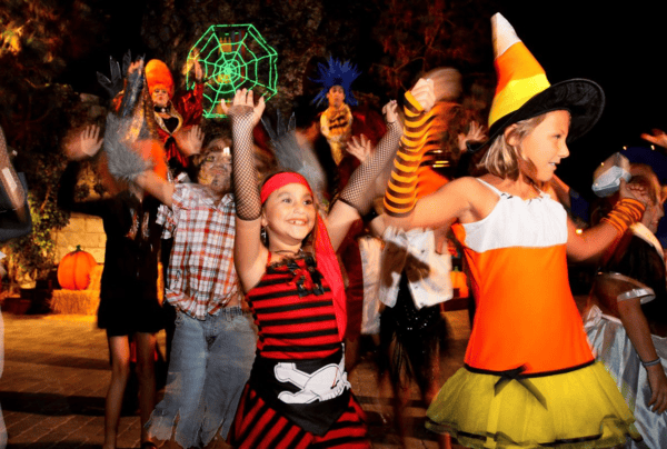 Kids in Halloween costumes dancing at Legoland California's Brick or Treat Dance Party.