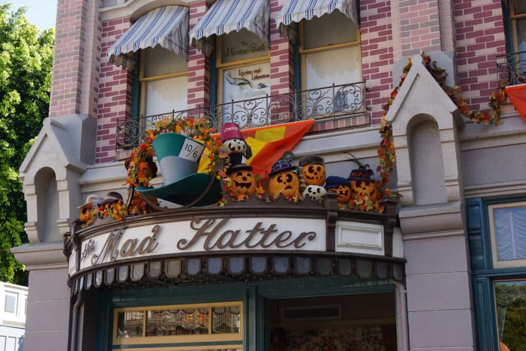 Exterior of The Mad Hatter shop at Disneyland decorated with jack-o-lanterns for Halloween.