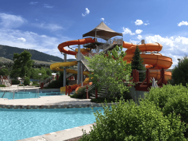 Large twisty orange and yellow water slide by pool in Missoula, Montana.