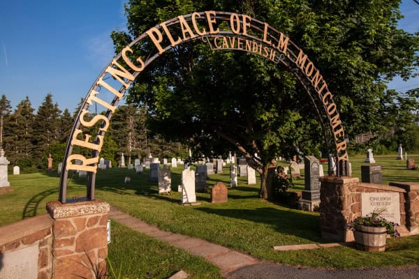 Curved sign at entrance to Cavendish Cemetery in Prince Edward Island, Canada reading Resting Place of L.M. Montgomery Cavendish.