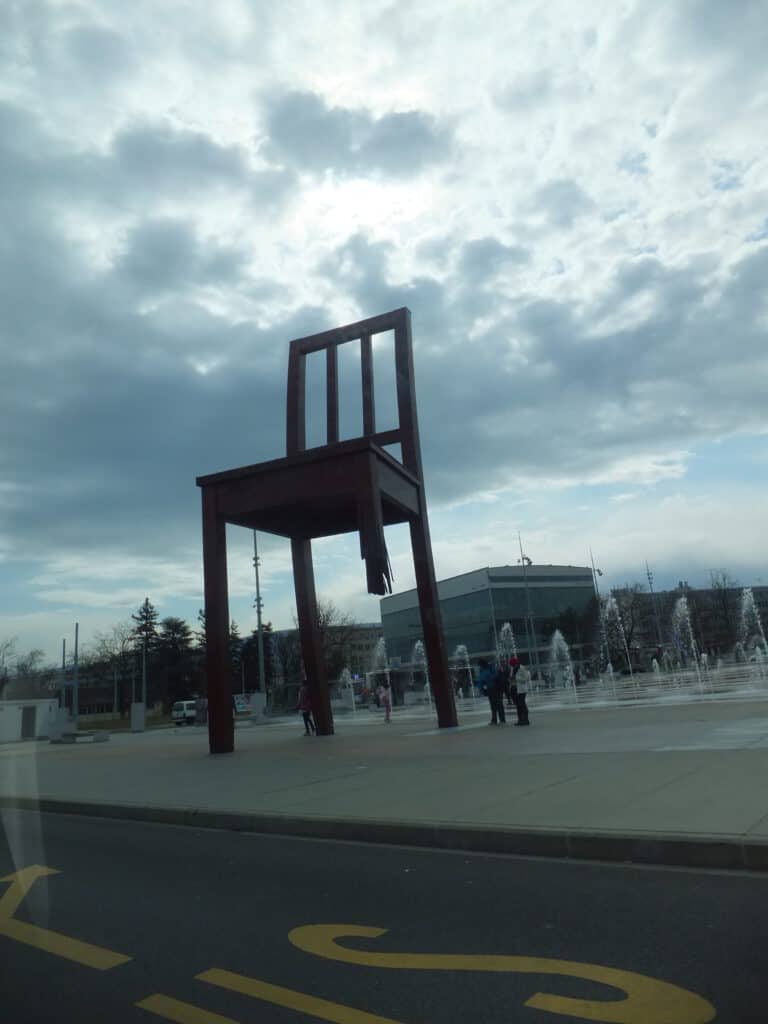 Large sculpture of a chair with one broken leg - memorial scultpure for victims of landmines in Geneva, Switzerland.