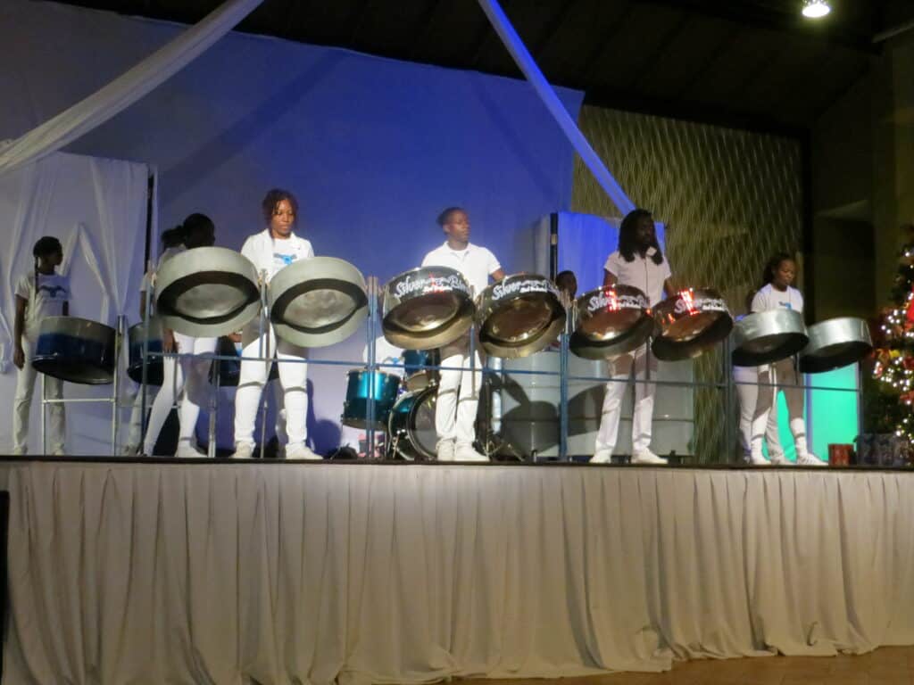 Members of steel drum band dressed in white perform on stage at Beaches Negril.