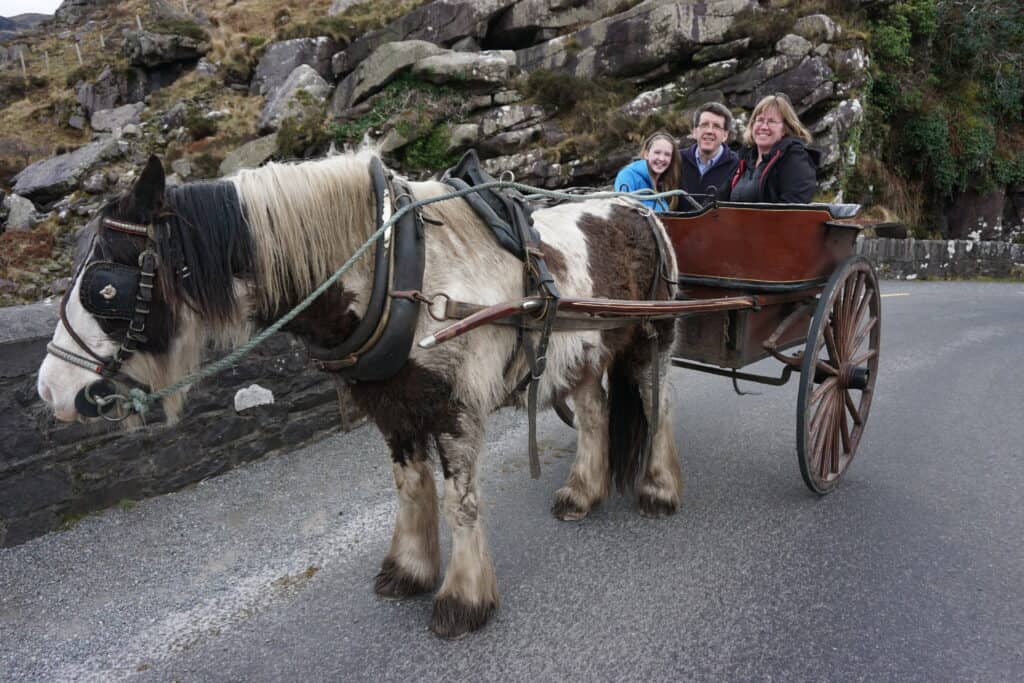 Horse and jaunting cart with man, woman and daughter in Killarney National Park, Ireland.