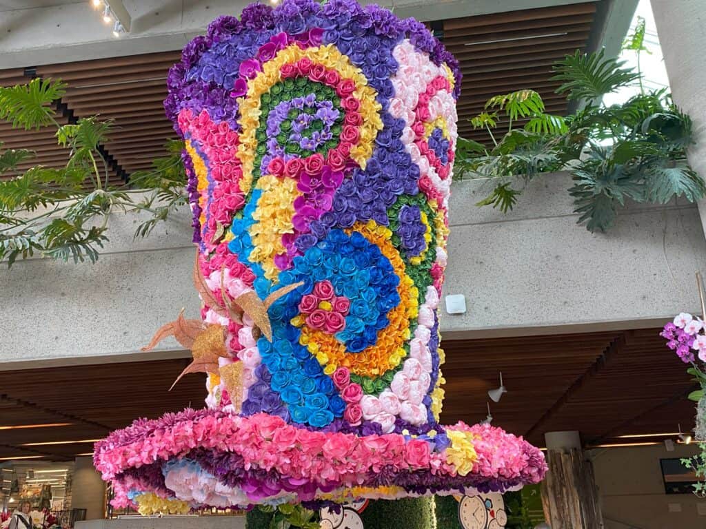 Large colourful top hat made from flowers suspended from ceiling at the Royal Botanical Gardens as part of the Alice in Bloomland showcase.